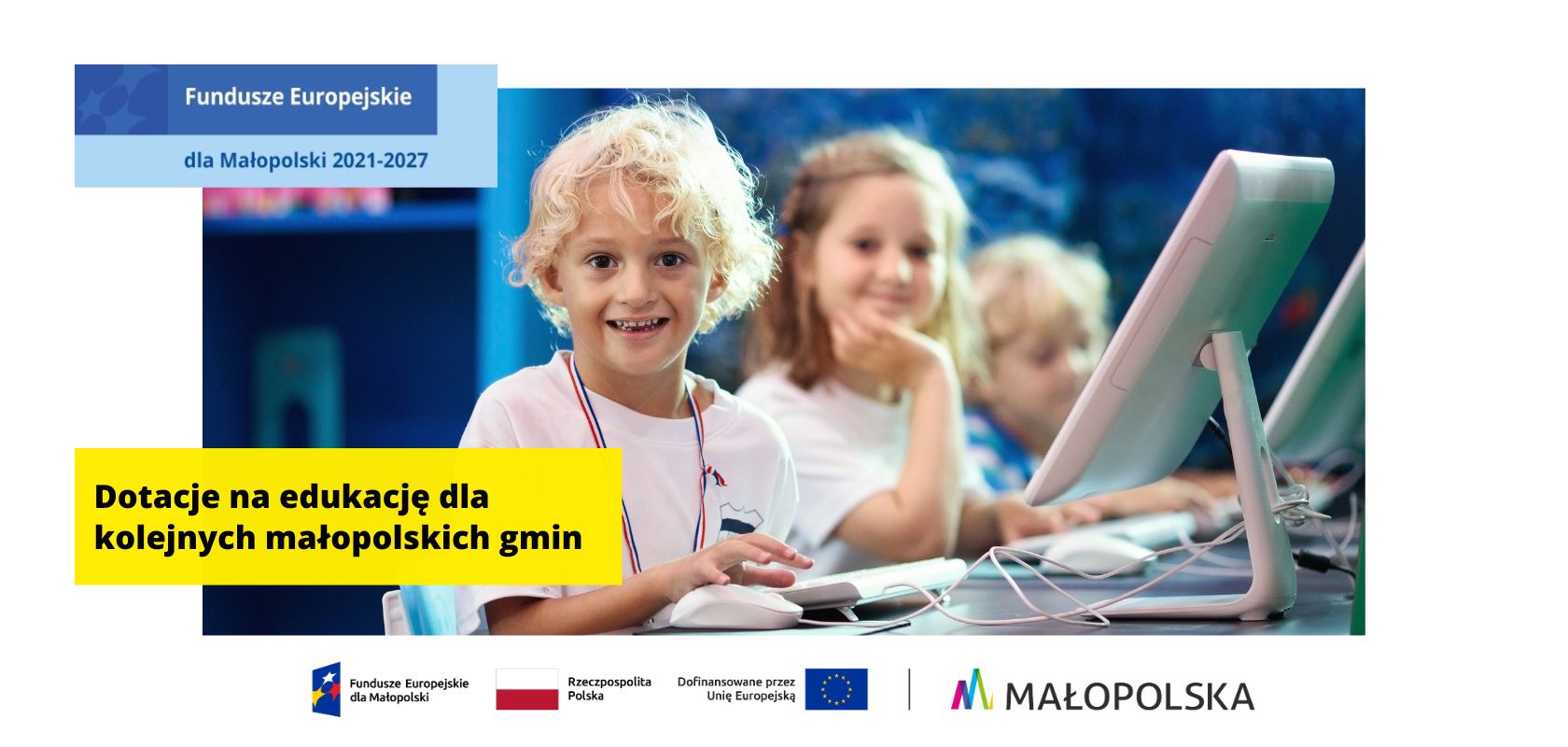 dzieci w wieku szkolnym: chłopiec na pierwszym planie, dziewczynki dalej, przy laptopach