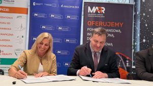 2 osoby przy stoliku podpisują umowę